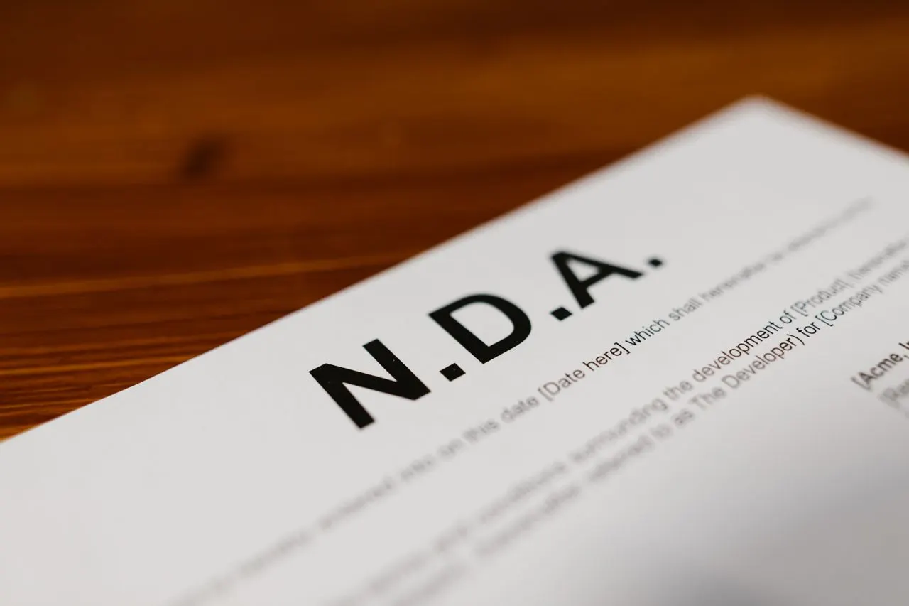 Close-up of a Non-Disclosure Agreement document on a wooden table, highlighting NDA confidentiality