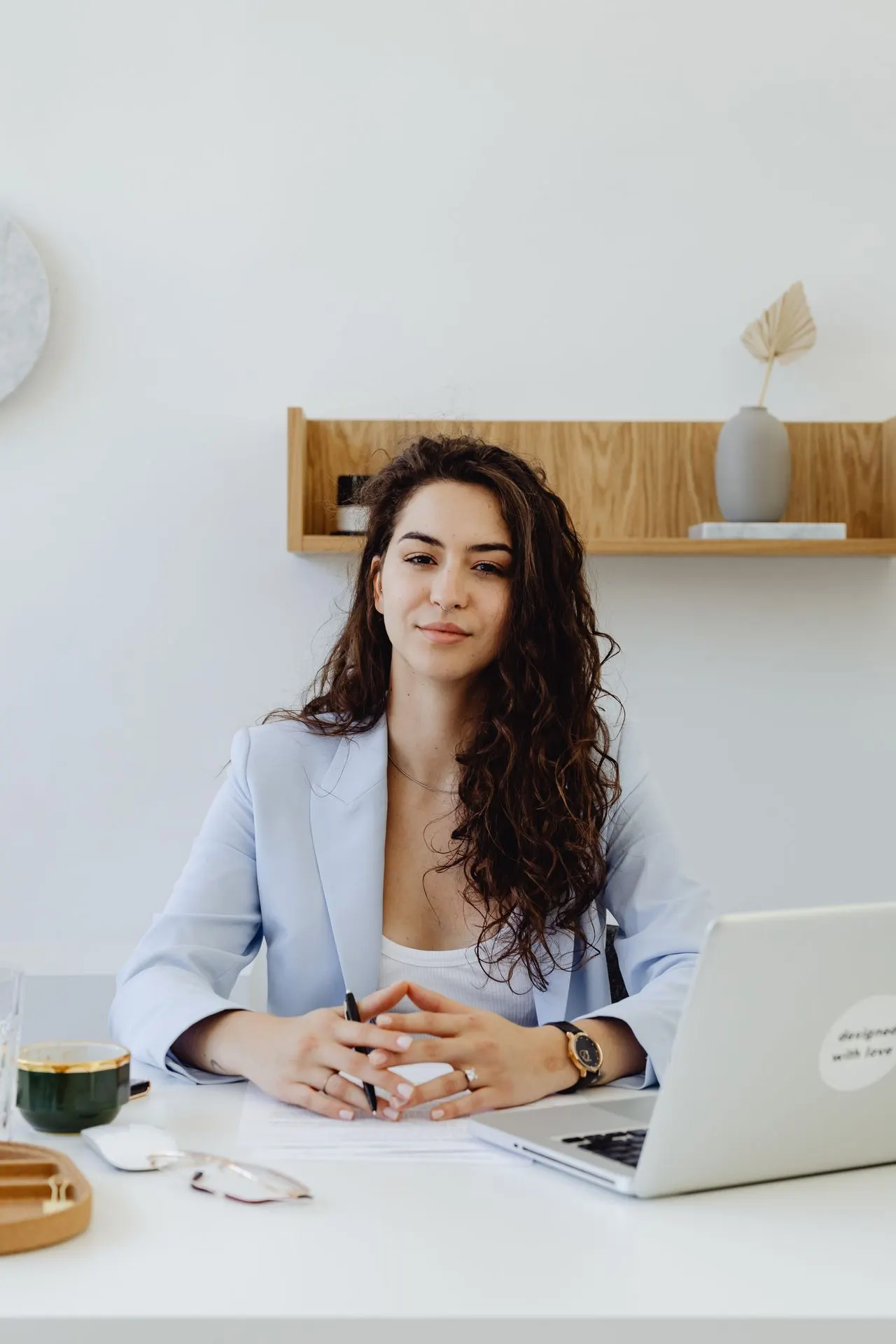 Confident professional businesswoman at a desk with a laptop, representing a business owner preparing to sell
